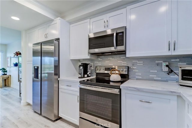 3365 Punta Alta Unit 2F, Laguna Woods, CA 92637 - kitchen featuring appliances with stainless steel finishes, backsplash, white cabinets, light wood-style floors, and ornamental molding