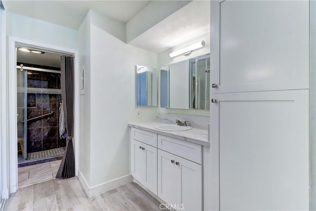 3365 Punta Alta Unit 2F, Laguna Woods, CA 92637 - bathroom with vanity, a tile shower, and wood finished floors