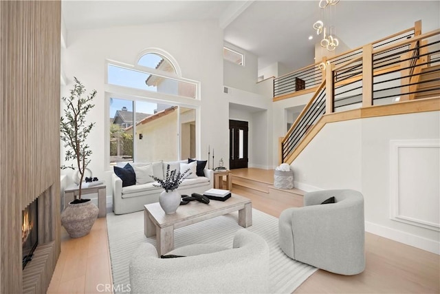 24876 Avenida Avalon, Laguna Hills, CA 92653 - living room featuring wood finished floors, stairway, a high ceiling, a large fireplace, and a chandelier