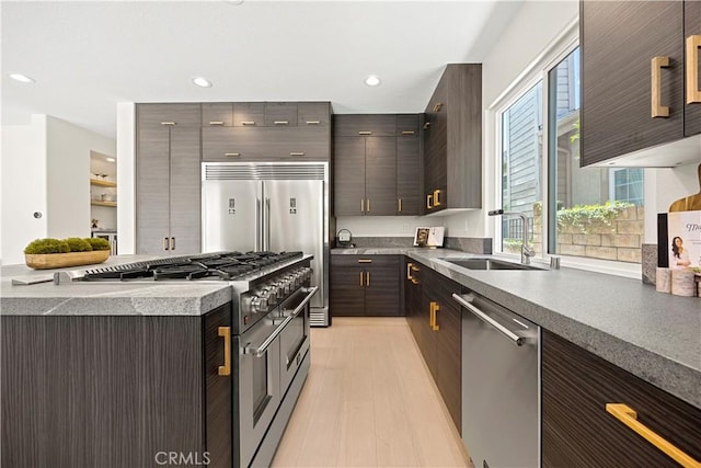 24876 Avenida Avalon, Laguna Hills, CA 92653 - kitchen featuring high end appliances, recessed lighting, dark brown cabinetry, light wood finished floors, and modern cabinets
