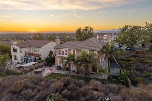 2886 Muir Trail Dr, Fullerton, CA 92833 - back of house at dusk with a patio, a tiled roof, a chimney, and stucco siding