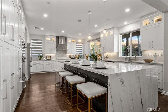 2886 Muir Trail Dr, Fullerton, CA 92833 - kitchen featuring wall chimney exhaust hood, a kitchen island, white cabinetry, decorative backsplash, and recessed lighting