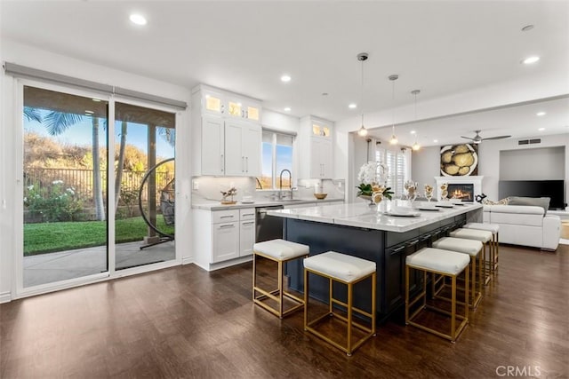 2886 Muir Trail Dr, Fullerton, CA 92833 - kitchen featuring dark wood-style flooring, a kitchen island, open floor plan, glass insert cabinets, and ceiling fan