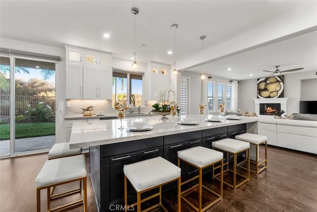 2886 Muir Trail Dr, Fullerton, CA 92833 - kitchen featuring white cabinets, dark wood-type flooring, a spacious island, open floor plan, and a breakfast bar