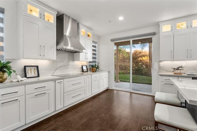 2886 Muir Trail Dr, Fullerton, CA 92833 - kitchen with wall chimney range hood, black electric cooktop, dark wood-style flooring, recessed lighting, and white cabinets