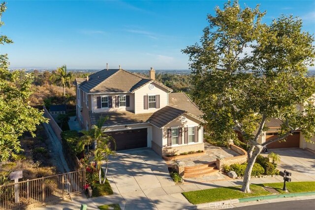 2886 Muir Trail Dr, Fullerton, CA 92833 - traditional-style home with driveway, an attached garage, a chimney, and a tile roof