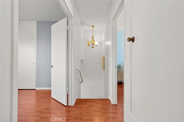 8515 Edgebrook Dr, Garden Grove, CA 92844 - corridor with wood finished floors, a textured ceiling, and a chandelier