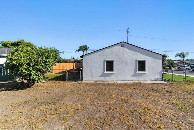 3839 Riverside Dr, Chino, CA 91710 - view of side of home with stucco siding and a gate