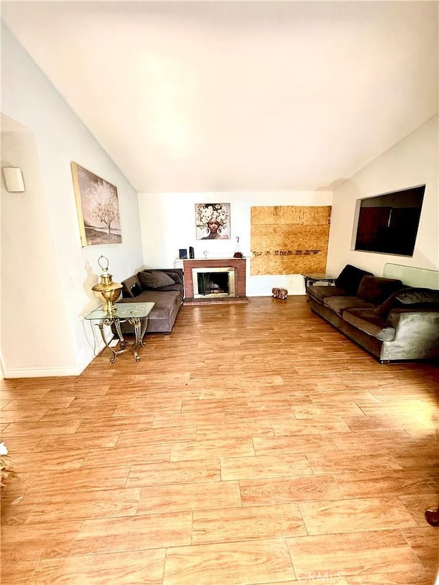 24423 Dunlavy Ct, Moreno Valley, CA 92557 - living area with lofted ceiling, light wood-style floors, and a brick fireplace