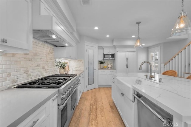 1605 Steinhart Ave, Redondo Beach, CA 90278 - kitchen with premium appliances, recessed lighting, white cabinets, decorative light fixtures, and wall chimney range hood