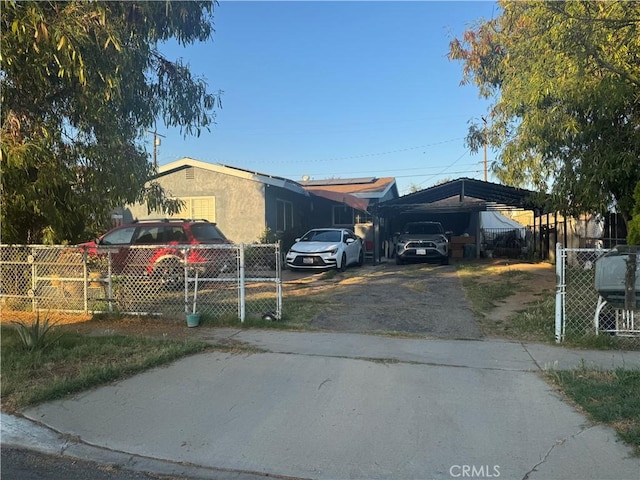 629 S Sage Ave, Rialto, CA 92376 - view of front facade with driveway, a detached carport, solar panels, and stucco siding