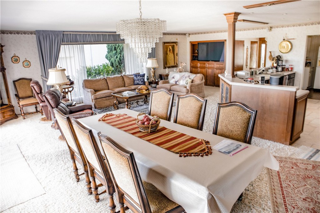 730 Saint James Pl, Newport Beach, CA 92663 - dining area featuring a chandelier, wallpapered walls, and ornate columns