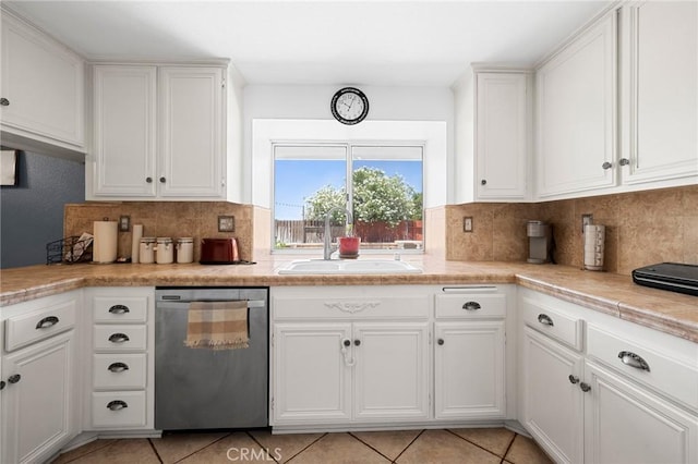 3143 Tourmaline Ln, Palmdale, CA 93550 - kitchen featuring stainless steel dishwasher, decorative backsplash, white cabinetry, light countertops, and light tile patterned floors