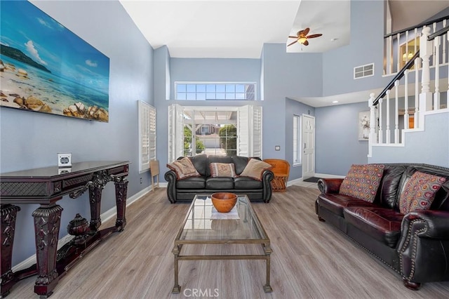 3143 Tourmaline Ln, Palmdale, CA 93550 - living area featuring a high ceiling, wood finished floors, ceiling fan, and stairs