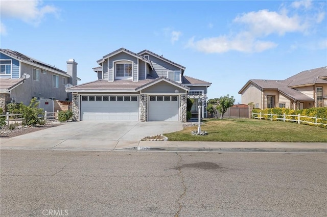 3143 Tourmaline Ln, Palmdale, CA 93550 - traditional-style house with a tiled roof, stone siding, concrete driveway, and a garage
