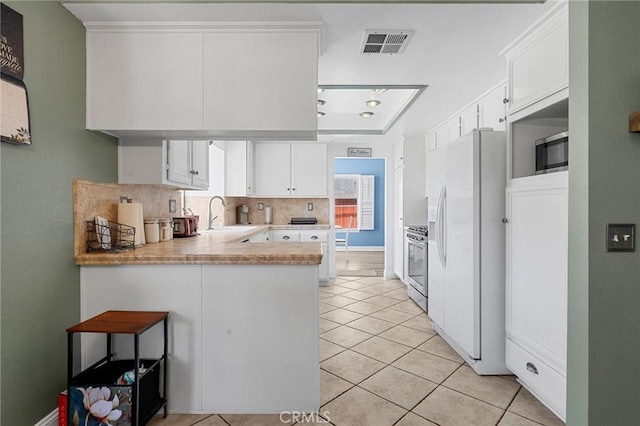3143 Tourmaline Ln, Palmdale, CA 93550 - kitchen featuring appliances with stainless steel finishes, a peninsula, light tile patterned flooring, light countertops, and backsplash