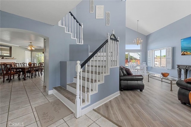 3143 Tourmaline Ln, Palmdale, CA 93550 - stairway featuring high vaulted ceiling, a ceiling fan, a chandelier, wood finished floors, and arched walkways