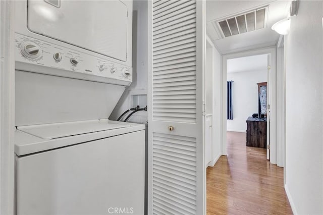26966 Flo Ln Unit 319, Canyon Country, CA 91351 - laundry room with stacked washing machine and dryer and light wood-type flooring