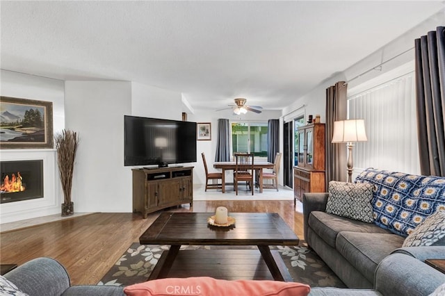 26966 Flo Ln Unit 319, Canyon Country, CA 91351 - living area with wood finished floors, a ceiling fan, and a fireplace with flush hearth