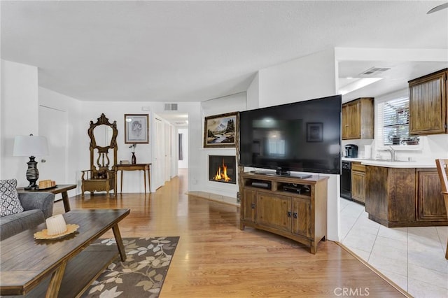 26966 Flo Ln Unit 319, Canyon Country, CA 91351 - living area featuring a glass covered fireplace and light wood-style flooring