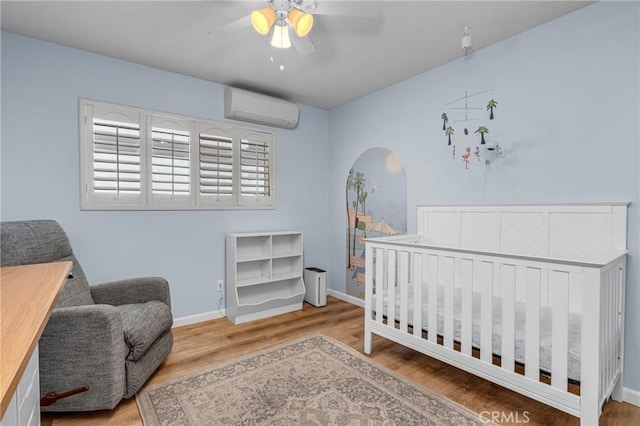 2433 S Gaffey St, San Pedro, CA 90731 - bedroom with a wall mounted air conditioner, wood finished floors, and a nursery area