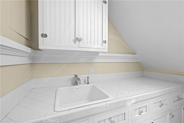 6025 E Ocean Blvd, Long Beach, CA 90803 - kitchen with tile counters, white cabinetry, and vaulted ceiling