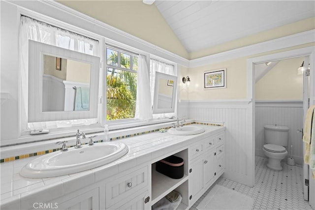 6025 E Ocean Blvd, Long Beach, CA 90803 - bathroom with lofted ceiling, double vanity, and wainscoting