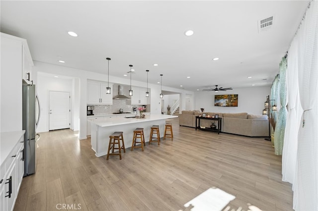 32084 Richardson St, Menifee, CA 92584 - kitchen featuring wall chimney exhaust hood, open floor plan, freestanding refrigerator, a breakfast bar, and recessed lighting