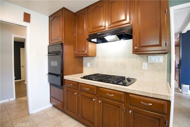 45011 16th St W, Lancaster, CA 93534 - kitchen featuring black appliances, a warming drawer, under cabinet range hood, backsplash, and light tile patterned flooring