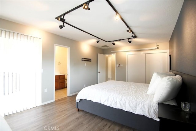 45011 16th St W, Lancaster, CA 93534 - bedroom with track lighting, wood finished floors, and connected bathroom