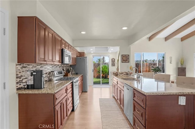 12674 Metate Ln, Poway, CA 92064 - kitchen with appliances with stainless steel finishes, tasteful backsplash, light wood-style floors, a kitchen island with sink, and light stone counters
