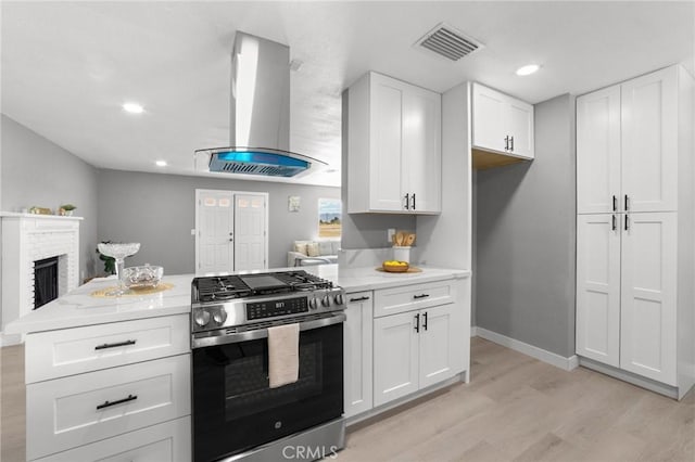 11343 1st Ave, Hesperia, CA 92345 - kitchen featuring stainless steel gas range oven, ventilation hood, light wood-style flooring, white cabinets, and recessed lighting