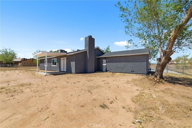 11343 1st Ave, Hesperia, CA 92345 - rear view of property featuring stucco siding, a patio area, and a chimney