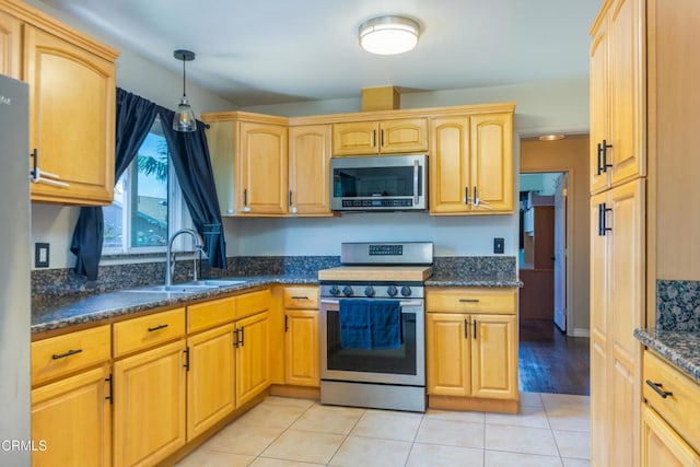312 Lafayette Dr, Oxnard, CA 93036 - kitchen with stainless steel appliances, dark stone counters, pendant lighting, light tile patterned floors, and light brown cabinetry