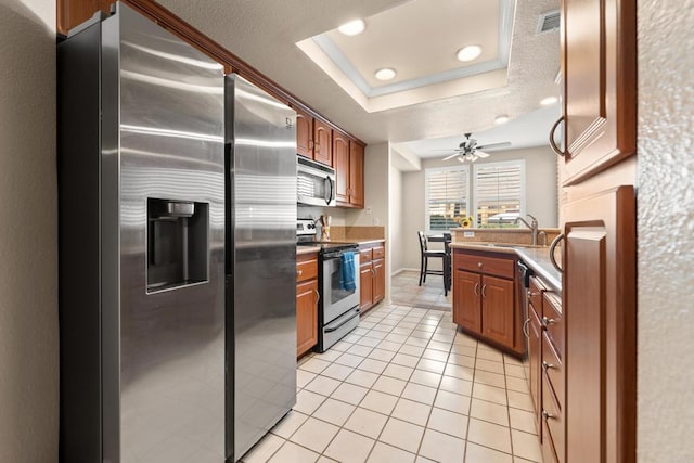 640 Camino De La Reina Unit 1108, San Diego, CA 92108 - kitchen featuring appliances with stainless steel finishes, a raised ceiling, light tile patterned flooring, recessed lighting, and brown cabinets