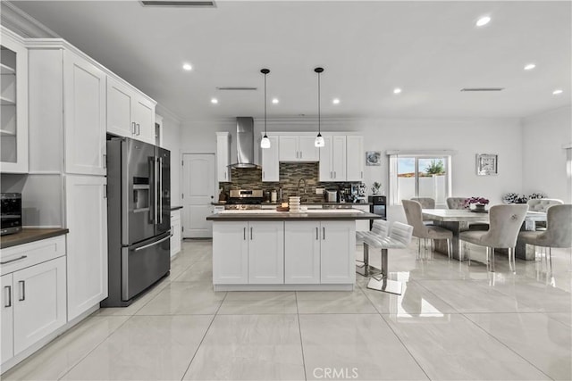 11209 Forbes Ave, Granada Hills, CA 91344 - kitchen with appliances with stainless steel finishes, wall chimney range hood, dark countertops, decorative backsplash, and white cabinetry