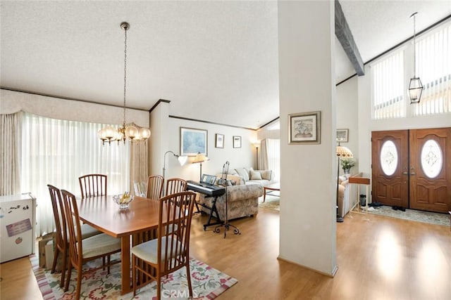 23484 Coyote Springs Dr, Diamond Bar, CA 91765 - dining space with light wood-style floors, a chandelier, a textured ceiling, and a towering ceiling