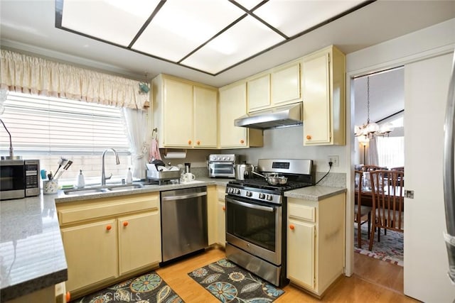 23484 Coyote Springs Dr, Diamond Bar, CA 91765 - kitchen with under cabinet range hood, appliances with stainless steel finishes, cream cabinetry, and light wood finished floors