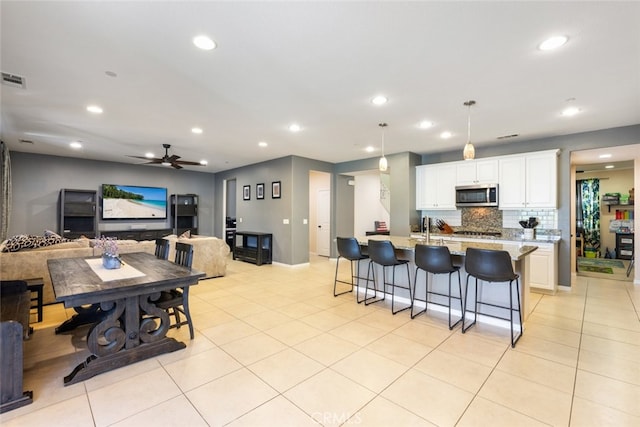 31572 Via Del Paso, Winchester, CA 92596 - kitchen with appliances with stainless steel finishes, recessed lighting, decorative backsplash, a breakfast bar area, and light tile patterned floors