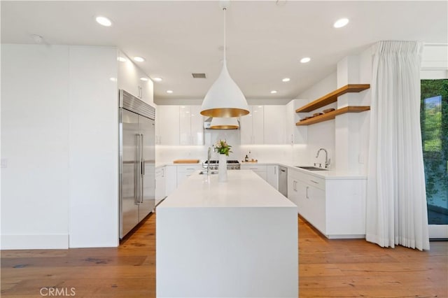 35481/2 Multiview Dr, Los Angeles, CA 90068 - kitchen with built in refrigerator, open shelves, a center island, white cabinets, and light wood-style flooring
