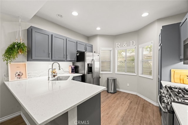 3732 Calle Monada, Riverside, CA 92503 - kitchen with appliances with stainless steel finishes, a peninsula, light wood-type flooring, light stone countertops, and recessed lighting