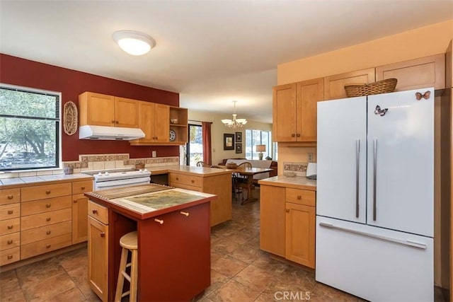 1410 Verde Canyon Rd, Arroyo Grande, CA 93420 - kitchen with white appliances, under cabinet range hood, a peninsula, tile counters, and a chandelier