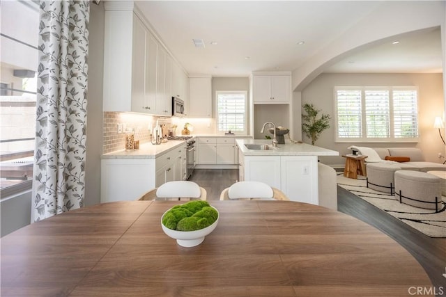 134 Milky Way, Irvine, CA 92618 - dining area featuring dark wood-style flooring, arched walkways, and recessed lighting