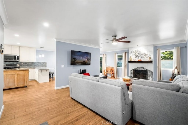 7985 Stella St, Riverside, CA 92504 - living room with a fireplace, crown molding, light wood-type flooring, a ceiling fan, and recessed lighting
