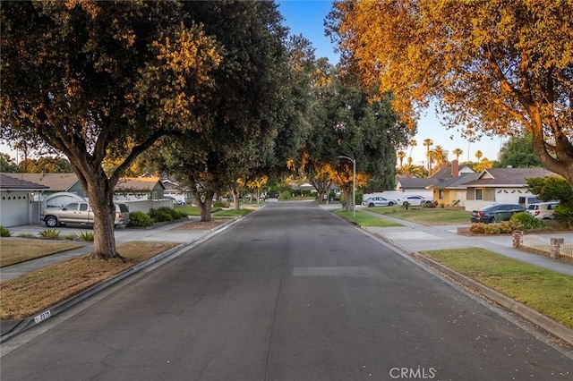 7985 Stella St, Riverside, CA 92504 - view of asphalt street with sidewalks, street lights, a residential view, and curbs