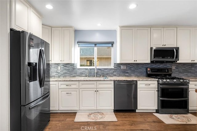 7985 Stella St, Riverside, CA 92504 - kitchen with stainless steel appliances, backsplash, dark wood finished floors, white cabinets, and recessed lighting