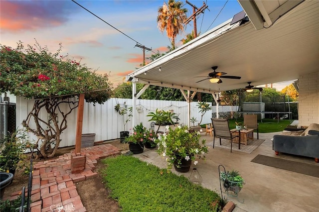 7985 Stella St, Riverside, CA 92504 - yard at dusk with a trampoline, a patio area, a fenced backyard, and ceiling fan