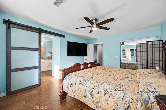 7985 Stella St, Riverside, CA 92504 - bedroom featuring a barn door, wood finished floors, a ceiling fan, and ensuite bathroom