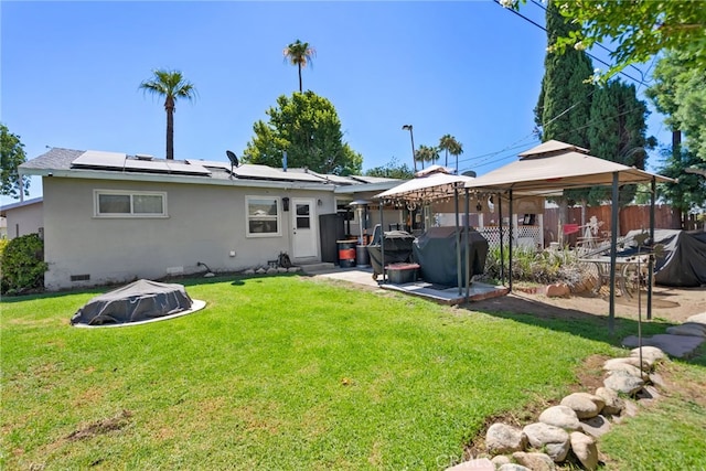 7430 Dunkirk Ave, Highland, CA 92346 - rear view of property with a gazebo, roof mounted solar panels, crawl space, and stucco siding