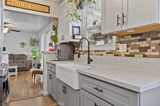 7430 Dunkirk Ave, Highland, CA 92346 - kitchen with gray cabinets, backsplash, a ceiling fan, light countertops, and light wood-style floors